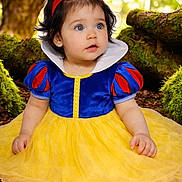 Arlett is registered to the contest to win money with this photo: baby, blue_eyes, child, costume, curly_hair, cute, dress, fairy_tale, forest, greenery, headband, moss, nature, outdoor, portrait, red_blue_top, sitting, snow_white, toddler, yellow_skirt