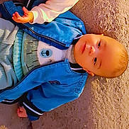 Bill participe au concours pour gagner de l'argent avec cette photo : baby, blue_jacket, carpet, child, clothing, cute, face, floor, hand, indoor, infant, looking, pants, person, portrait, sitting, small_child, soft_light, tiled_floor, young_child