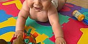 Tiago a rejoint le concours — aidez-le/la à gagner de superbes lots ! baby, bright_colors, child, colorful, crawling, cute, diaper, floor, foam_mat, happy, indoor, infant, person, playtime, plush_toy, smiling, soft_toys, toy, wooden_floor, young_child