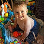 baby, bare_chest, blanket, child, colorful, cute, face, foot, hand, happy, indoor, infant, pants, person, playmat, plush, rattle, sitting, smiling, toy