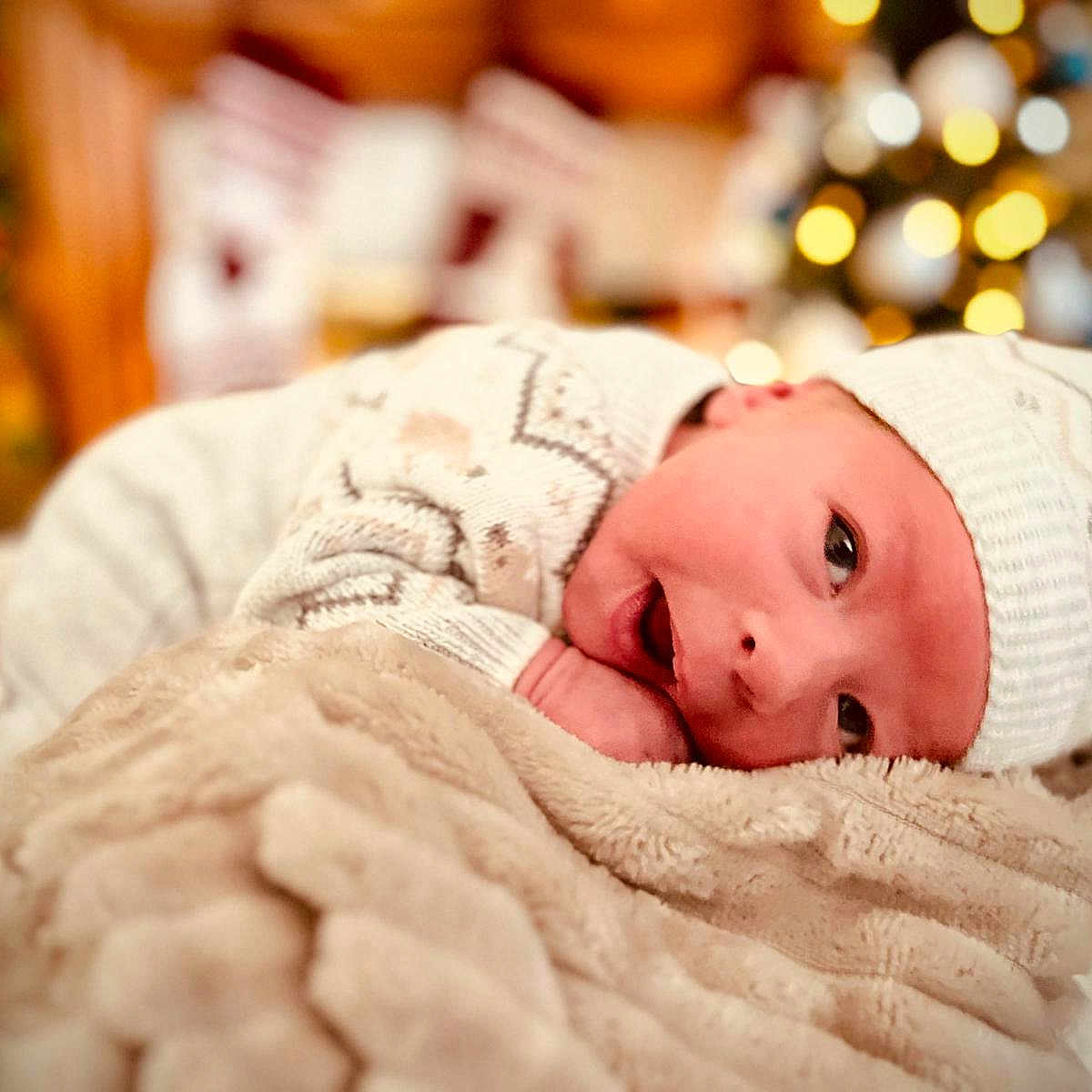 Luca is registered to the contest to win money with this photo: baby, blanket, clothing, face, happy, hat, head, newborn, person, photography, portrait, quilt, sleeping, smile
