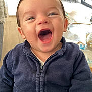 Livio a rejoint le concours — aidez-le/la à gagner de superbes lots ! baby, child, smiling, laughing, indoor, sweater, navy_blue, happy, face, mouth_open, cute, person, young_child, portrait, cozy, expression, fun, warm, casual, human