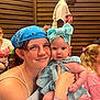 Winifred joined the competition — help win amazing prizes! baby, child, woman, bandana, blue_bow, striped_dress, indoor, wooden_wall, people, casual_clothing, smile, holding, affection, portrait, closeup, family, candid, happy, skin, person