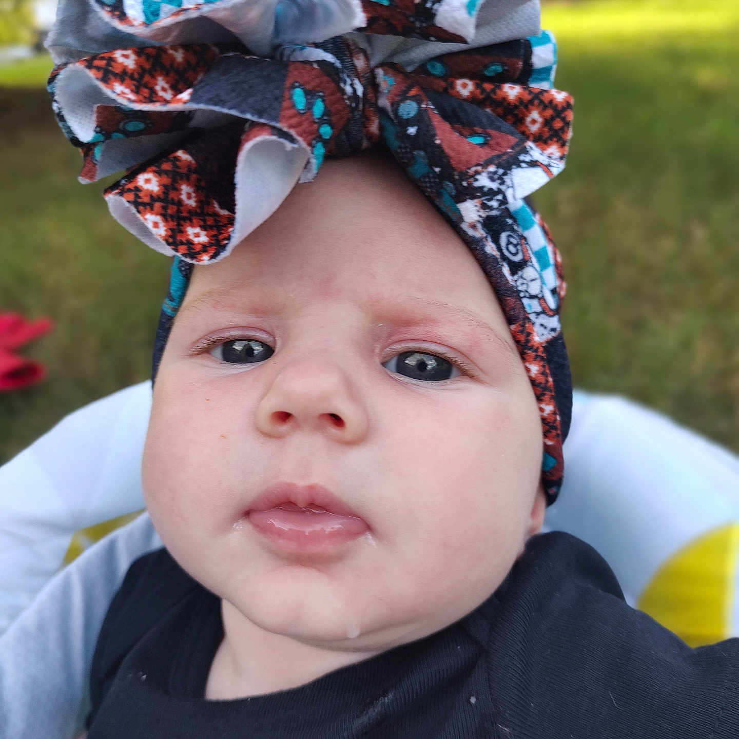 Winifred is registered to the contest to win money with this photo: apparel, baby, babyface, background, bow, child, closeup, clothing, cute, drool, expression, face, headband, headwear, infant, outdoor, person, portrait, skin, young