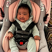 Seaenna is registered to the contest to win money with this photo: baby, infant, child, smiling, happy, portrait, car_seat, car_safety, harness, buckled, pink, green, clothing, hood, socks, seated, indoor, close_up, automobile, joy