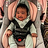baby, infant, child, smiling, happy, portrait, car_seat, car_safety, harness, buckled, pink, green, clothing, hood, socks, seated, indoor, close_up, automobile, joy