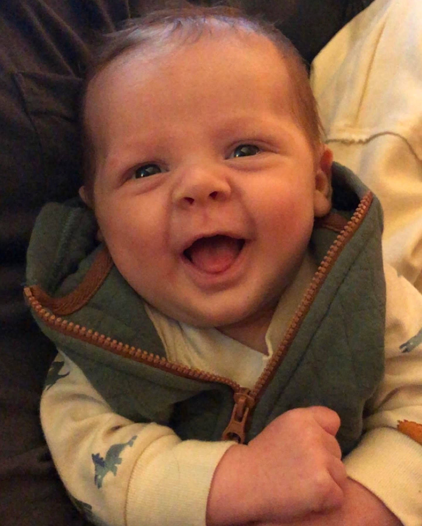 Robbie is registered to the contest to win money with this photo: baby, baby_toddler_clothing, cheek, comfort, ear, eye, eyebrow, finger, gesture, happy, human_body, iris, lip, mouth, nose, person, skin, sleeve, smile, toddler