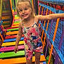 child, girl, smiling, indoor_playground, colorful, bridge, netting, play_area, socks, clothing, happy, fun, active, young_child, play, feet, hair, face, summer_outfit, balance
