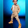 Tymair is registered to the contest to win money with this photo: child, boy, cap, boots, beige_jumpsuit, pose, studio, blue_background, fashion, confident, standing, portrait, cute, casual_clothing, footwear, hat, young, person, model, expression