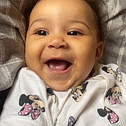 Delilah joined the competition — help win amazing prizes! baby, smiling, infant, cute, face, child, clothing, minnie_mouse, pattern, happy, lying_down, blanket, portrait, closeup, young_child, toddler, skin, hair, eyes, mouth