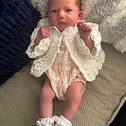 Isabelle joined the competition — help win amazing prizes! baby, infant, newborn, knitted_cardigan, white_socks, blanket, cushion, soft_texture, beige, navy, clothing, person, portrait, indoors, resting, cute, small_hands, legs, face, sleepwear