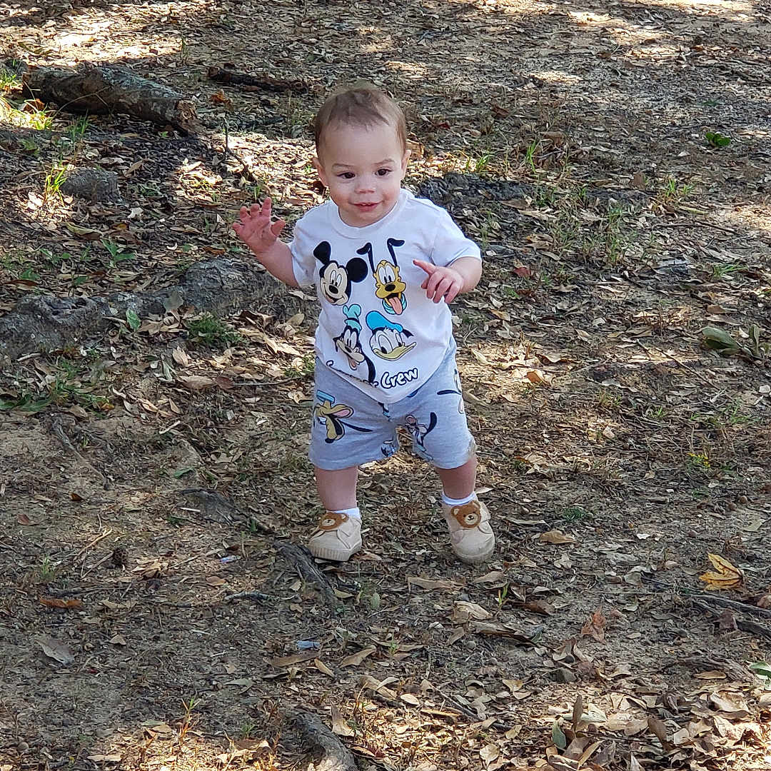 Hush is registered to the contest to win money with this photo: baby, clothing, face, footwear, grass, head, machine, outdoors, pants, person, photography, plant, portrait, shoe, shorts, soil, spoke, tree, vegetation, wheel