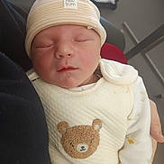 Leandro participe au concours pour gagner de l'argent avec cette photo : newborn, baby, sleeping, hat, onesie, teddy_bear, infant, clothing, person, hand, closeup, soft_light, indoors, cute, peaceful, resting, child, human, portrait, warm