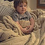 toddler, child, blanket, cozy, indoor, couch, smile, face, hands, comfort, warm, soft, home, furniture, young_child, portrait, casual_clothing, relaxation, cute, expression