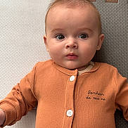 Célestin participe au concours pour gagner de l'argent avec cette photo : baby, infant, child, face, eyes, clothing, buttoned_shirt, orange, play_mat, texture, portrait, lying_down, cute, young_child, skin, expression, indoors, soft_light, close_up, person