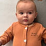 baby, infant, child, face, eyes, clothing, buttoned_shirt, orange, play_mat, texture, portrait, lying_down, cute, young_child, skin, expression, indoors, soft_light, close_up, person