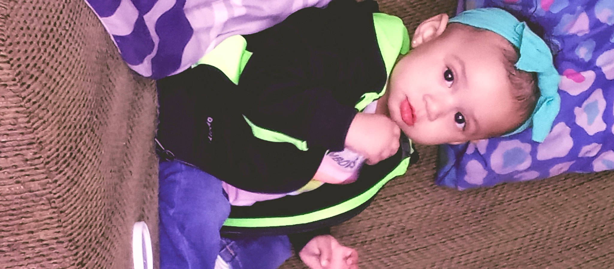 La'Niya is registered to the contest to win money with this photo: baby, baby_products, baby_toddler_clothing, cheek, child, event, finger, fun, grass, green, magenta, person, personal_protective_equipment, pink, purple, sitting, toddler, tree, violet