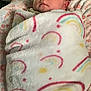 Amoura joined the competition — help win amazing prizes! baby, blanket, sleeping, face, child, bed, pillow, floral_pattern, video_call, screen, indoor, soft_texture, wrapped, peaceful, infant, person, cozy, comfort, portrait, blanket_pattern