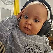 Oscar a rejoint le concours — aidez-le/la à gagner de superbes lots ! baby, cat, child, clock, cozy, curious, curtain, cute, expression, face, furniture, headphones, home, indoor, orange, person, portrait, striped, sweater, table