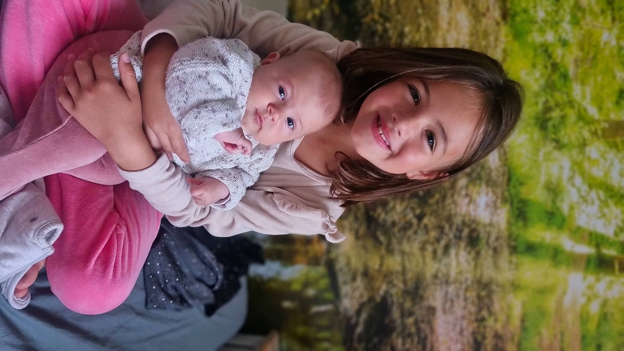 Mia a rejoint le concours — aidez-le/la à gagner de superbes lots ! baby, baby_toddler_clothing, child, flash_photography, fun, grass, happy, joy, laugh, lip, people_in_nature, person, plant, portrait_photography, sibling, sitting, skin, smile, toddler, tree