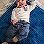 Benoît participe au concours pour gagner de l'argent avec cette photo : baby, laughing, blue_blanket, white_shirt, denim_jeans, baby_clothing, infant, happy, cute, smiling, indoor, floor_tiles, textured_blanket, child, casual_wear, footwear, raised_arm, portrait, laying_down, baby_footwear