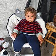 Lyano participe au concours pour gagner de l'argent avec cette photo : toddler, child, chair, plush_chair, striped_sweater, navy_pants, socks, shoes, plush_toy, koala_toy, wooden_stool, tile_floor, indoor, wall_texture, cute, smiling, seated, person, home_interior, furniture