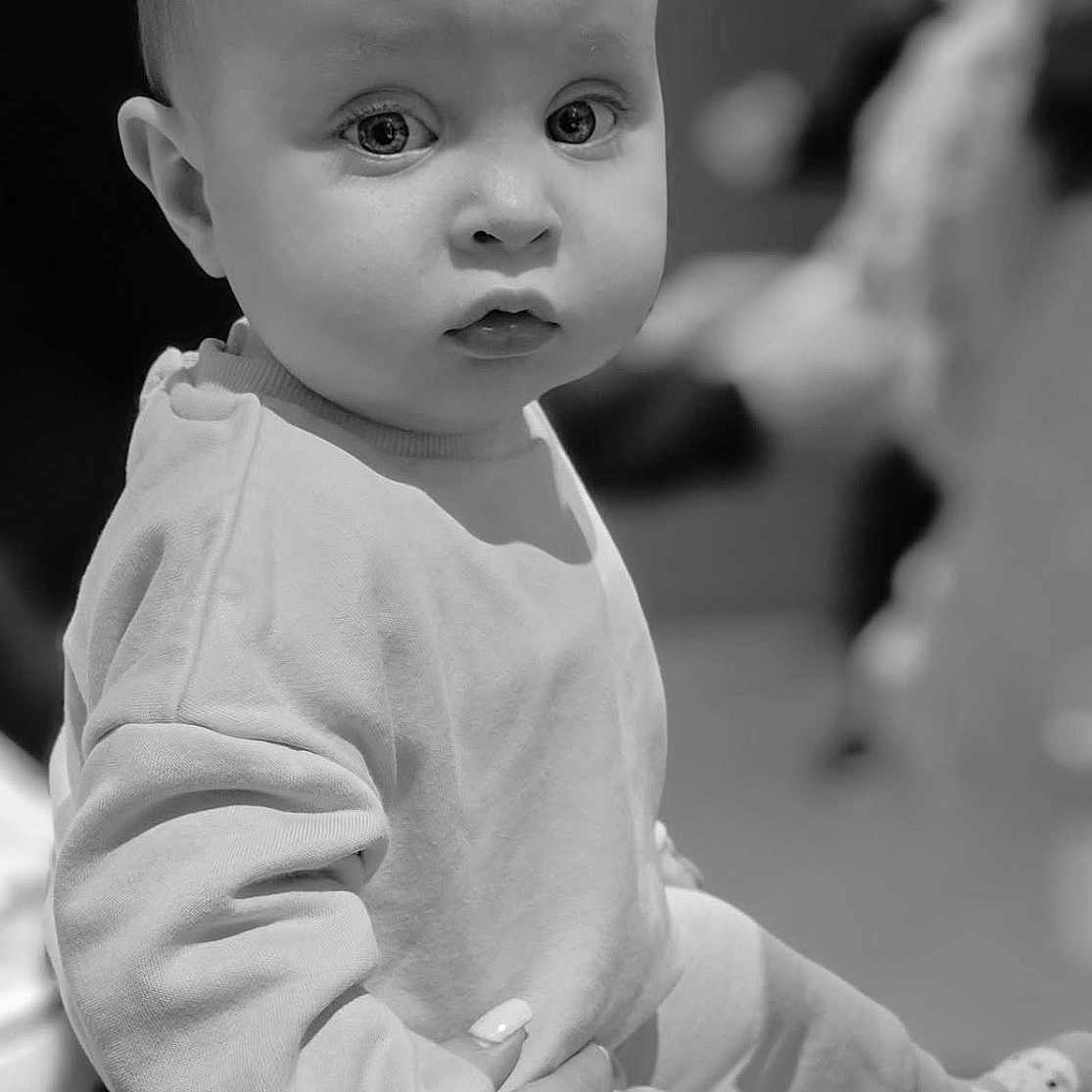 Lyana a rejoint le concours — aidez-le/la à gagner de superbes lots ! adorable, baby, black_and_white, child, clothing, cute, expression, eyes, face, hand, holding, indoor, infant, monochrome, person, portrait, small, socks, soft_focus, young