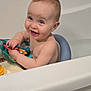 baby, bath_seat, bath_toy, bathroom, bathtub, blue_eyes, child, hair, happy, infant, looking_at_camera, playful, portrait, sitting, skin, smile, tiles, toy_xylophone, tub_rim, white
