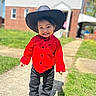 child, toddler, cowboy_hat, red_shirt, black_pants, shoes, smiling, portrait, outdoor, sunny, front_yard, house, brick_house, lawn, sidewalk, standing, fashion, happy, western, family_photo