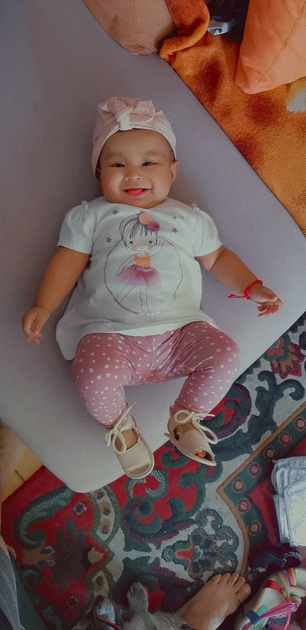 Kayla participe au concours pour gagner de l'argent avec cette photo : baby, baby_toddler_clothing, cap, cheek, child, comfort, dress, eye, face, happy, headwear, joy, linens, magenta, person, pink, skin, sleeve, smile, sock