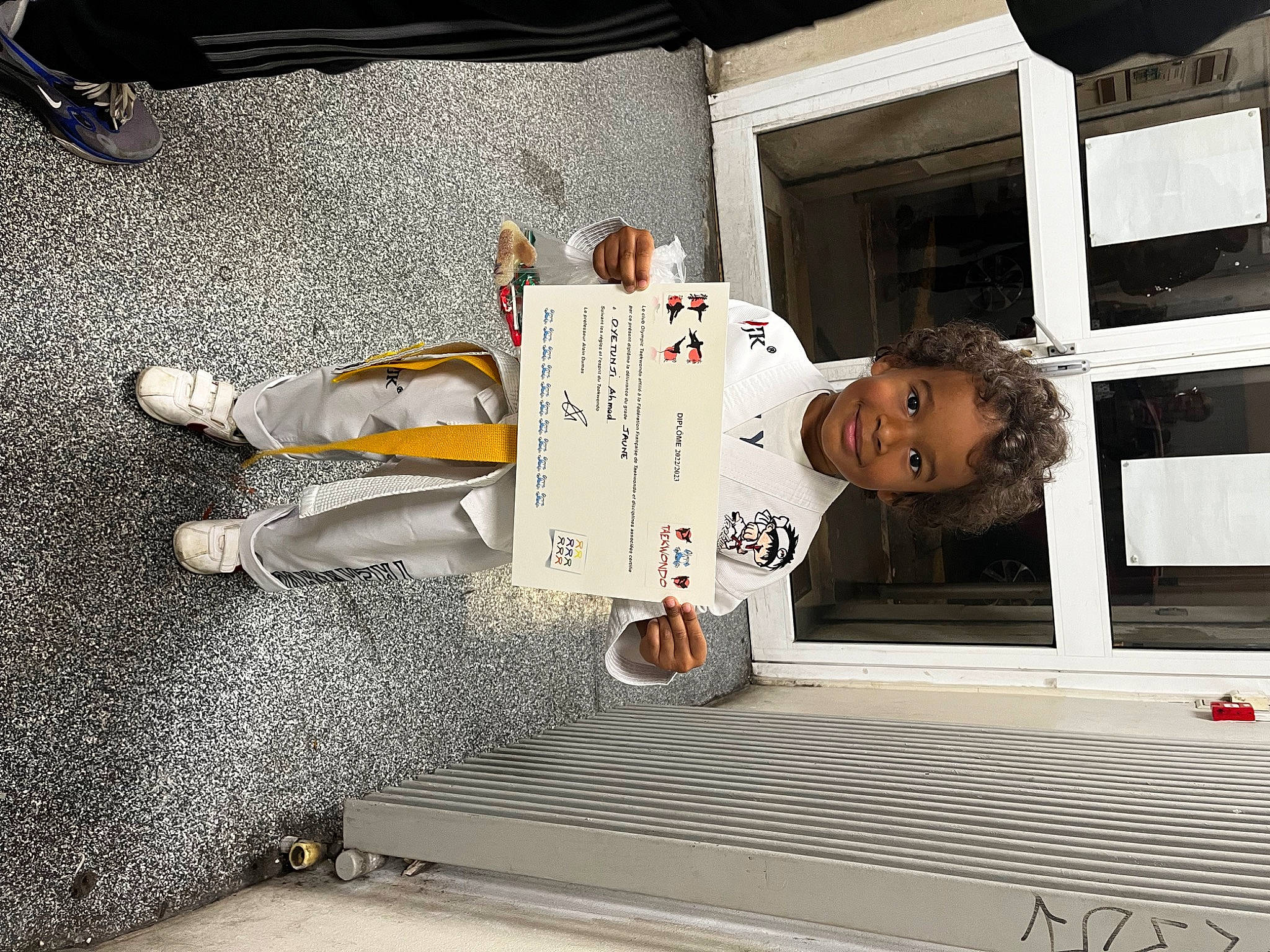 Ahmed a rejoint le concours — aidez-le/la à gagner de superbes lots ! asphalt, baby, baby_toddler_clothing, carmine, child, floor, flooring, human_leg, joy, pedestrian, person, road_surface, room, shoe, sidewalk, smile, snapshot, toddler, walking_shoe, wood