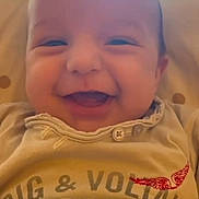 Ghjuvanni a rejoint le concours — aidez-le/la à gagner de superbes lots ! baby, smiling, face, infant, clothing, beige, closeup, happy, child, person, portrait, casual, cute, young, sitting, text, button, fabric, indoors, soft