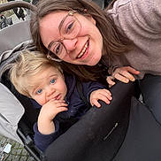Eden participe au concours pour gagner de l'argent avec cette photo : child, toddler, woman, glasses, stroller, smile, outdoor, cobblestone, hand, clothing, person, face, happy, baby, hair, jacket, seat, hoodie, casual, portrait