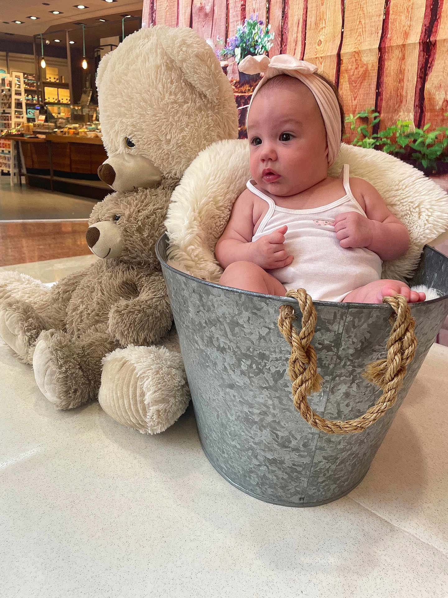 Catalyna a rejoint le concours — aidez-le/la à gagner de superbes lots ! baby, bucket, headband, teddy_bear, plush_toy, blanket, indoor, child, soft_toy, metal_bucket, curious, seated, clothing, floor, decor, person, cute, expression, small_child, toy