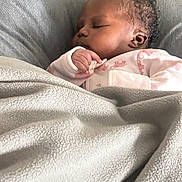 Oshun is registered to the contest to win money with this photo: baby, blanket, child, closeup, comfort, couch, cozy, curly_hair, cute, furniture, indoors, infant, one_person, peaceful, portrait, relaxation, resting, sleeping, soft, wearing_pajamas