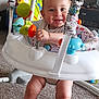 Alexander is registered to the contest to win money with this photo: baby, child, smile, indoor, jumper, toy, carpet, furniture, person, happy, colorful, legs, hand, face, play, home, living_room, infant, clothing, seat