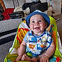 Alexander joined the competition — help win amazing prizes! baby, child, blue_hat, bib, smiling, baby_seat, indoor, car_pattern, colorful, happy, person, furniture, couch, toy, carpet, pacifier, foot, hand, headwear, infant