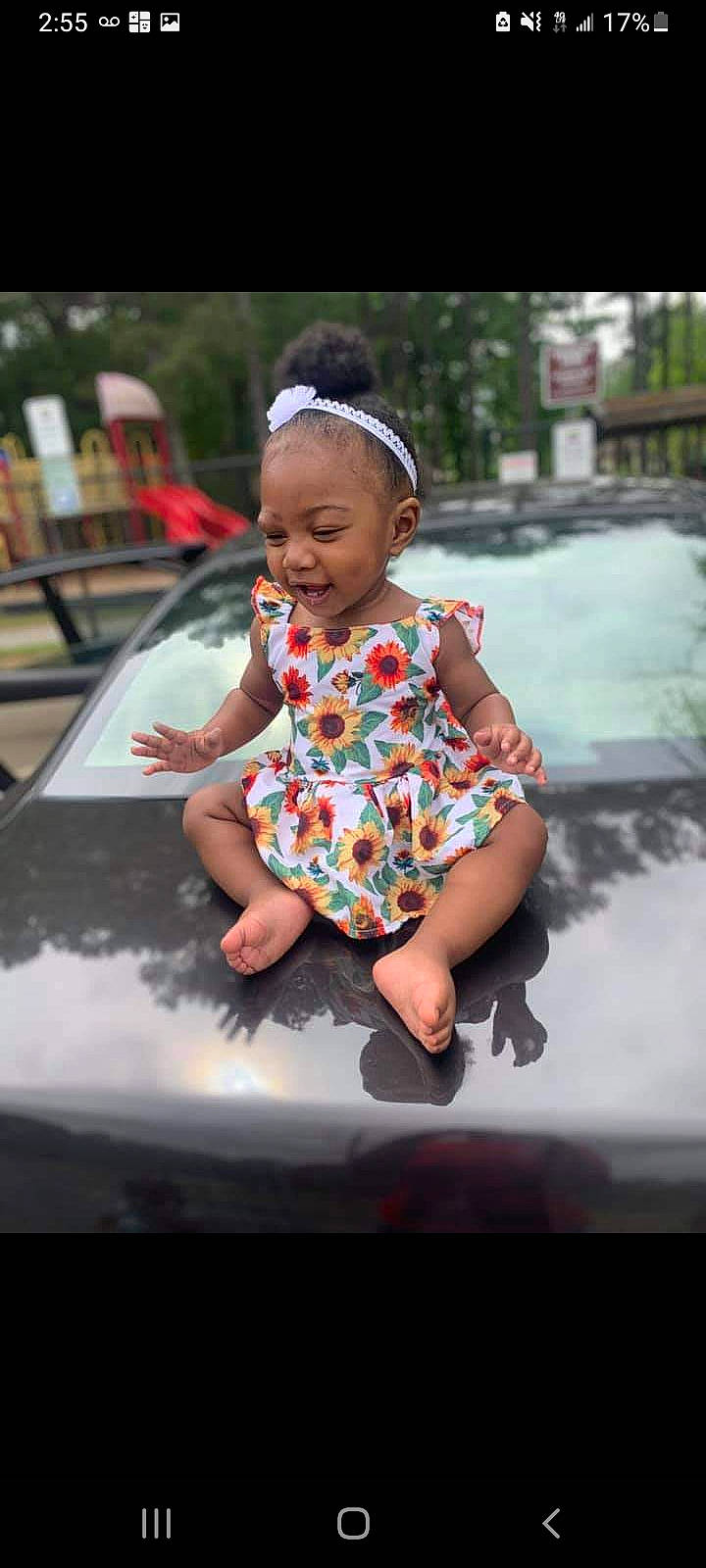 Ny'Jane is registered to the contest to win money with this photo: automotive_window_part, baby, baby_toddler_clothing, child, flash_photography, fun, grass, happy, leisure, magenta, mammal, pattern, person, pink, recreation, sitting, sleeve, smile, t_shirt, toddler