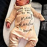 newborn, baby, infant, onesie, clothing, text, message, cushion, lying_down, peaceful, soft_lighting, portrait, child, sleepy, indoor, cute, human, small, toddler, love