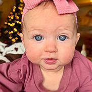 Wrenlee is registered to the contest to win money with this photo: baby, infant, bow_headband, pink_bow, blue_eyes, closeup, portrait, blanket, bokeh_lights, christmas_tree, holiday_decor, chubby_cheeks, gaze, indoor, soft_texture, cozy, clothing, face, headband, propped_up