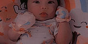 Iliyah is registered to the contest to win money with this photo: baby, infant, mittens, blanket, pillow, rainbow, smiling, cute, lying_down, indoors, child, face, apparel, sleepwear, soft, colorful, expression, person, young, resting