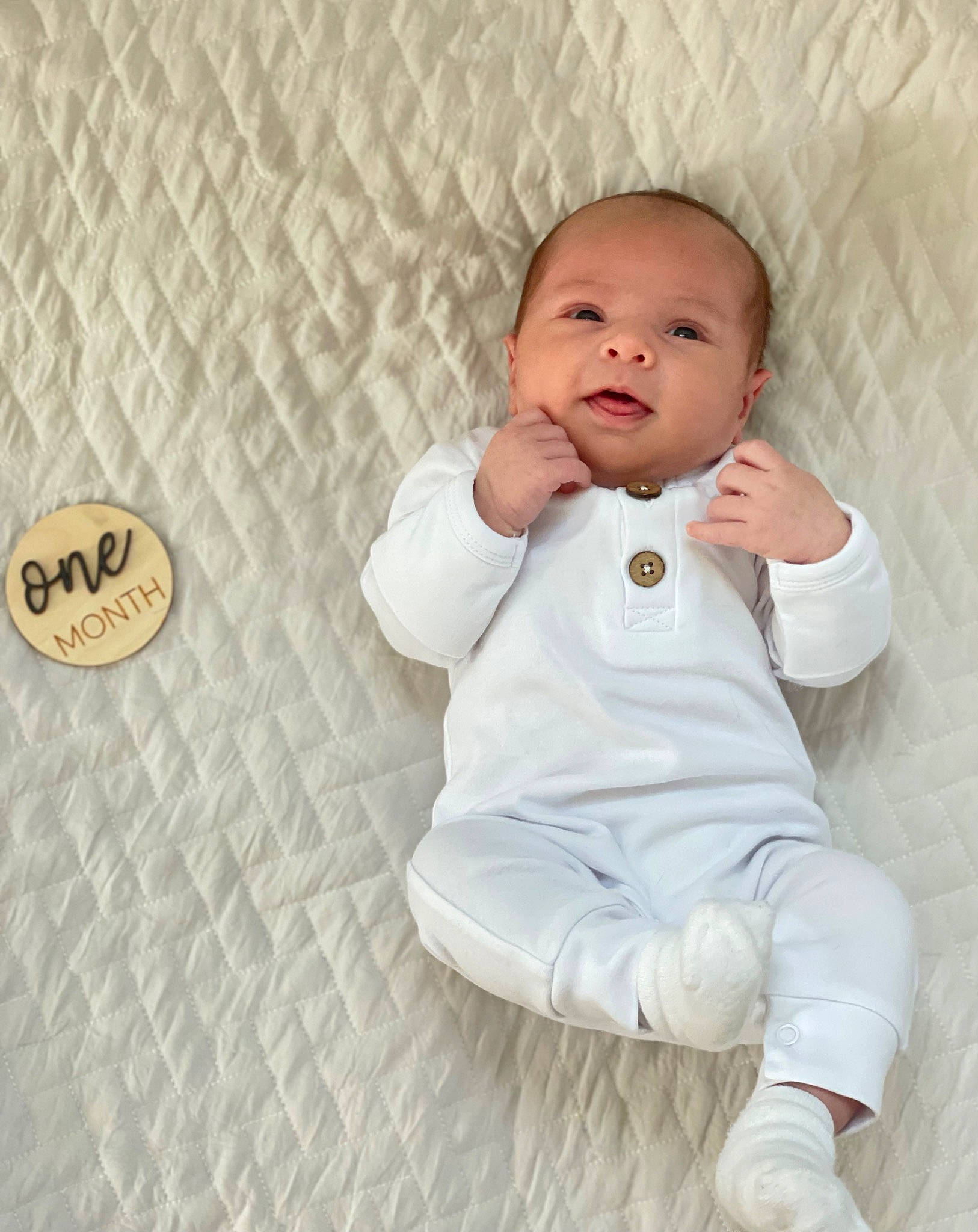 Jett is registered to the contest to win money with this photo: baby, baby_toddler_clothing, cheek, child, chin, comfort, finger, flash_photography, floor, flooring, gesture, happy, linens, nose, pattern, person, product, skin, sleeve, textile