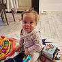 Alice a rejoint le concours — aidez-le/la à gagner de superbes lots ! baby, child, indoor, floor, toy, blanket, smile, cute, girl, sitting, clothing, play, infant, flooring, furniture, colorful, soft, warm, curious, bow