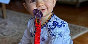 Matilde a rejoint le concours — aidez-le/la à gagner de superbes lots ! baby, child, pacifier, headband, white_shirt, blue_embroidery, floor, carpet, smiling, sitting, indoors, cute, colorful, clothing, happy, portrait, toddler, accessory, person, home