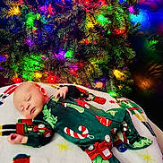Anakin joined the competition — help win amazing prizes! baby, sleeping, christmas_tree, holiday_lights, festive_pajamas, blanket, holiday_theme, infant, cozy, colorful, decorations, indoors, celebration, christmas, festive, child, cute, holiday, sleep, relaxation