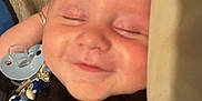 Ronnie-Lee is registered to the contest to win money with this photo: baby, pacifier, smiling, sleeping, blanket, closeup, infant, face, child, resting, comfort, cute, toddler, indoor, soft, peaceful, skin, clothing, lying_down, relaxed