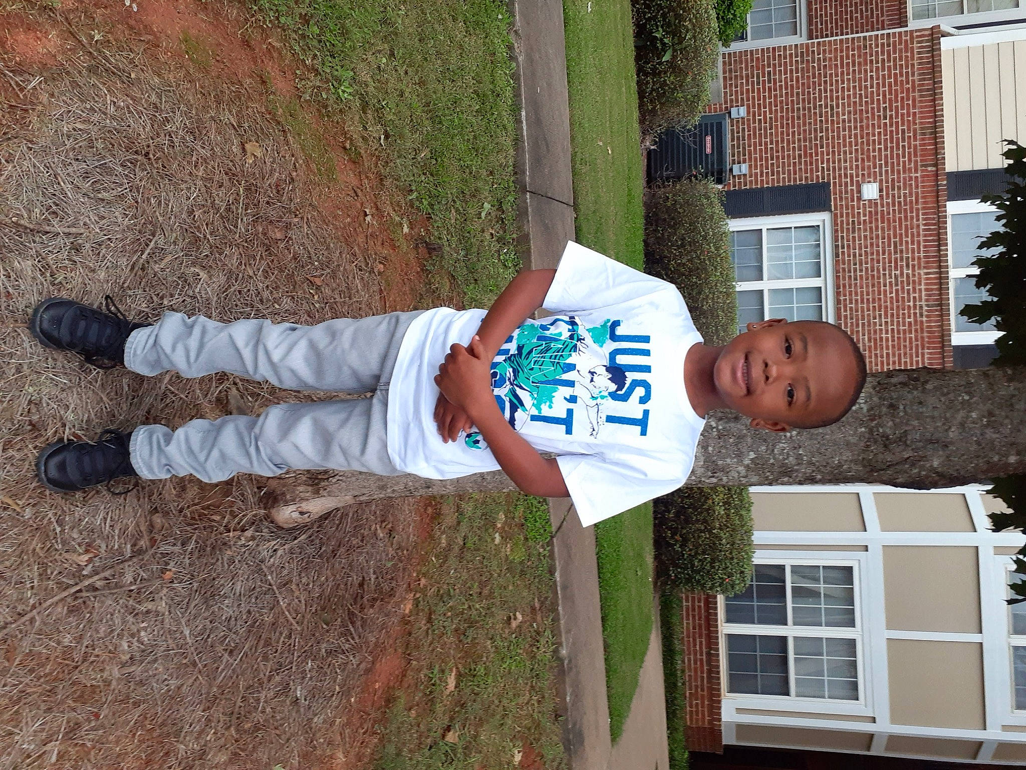 Cameo is registered to the contest to win money with this photo: building, elbow, fixture, fun, grass, hat, house, human_leg, joy, outdoor_shoe, person, plant, sash_window, soil, t_shirt, thigh, toddler, tree, walking_shoe, window