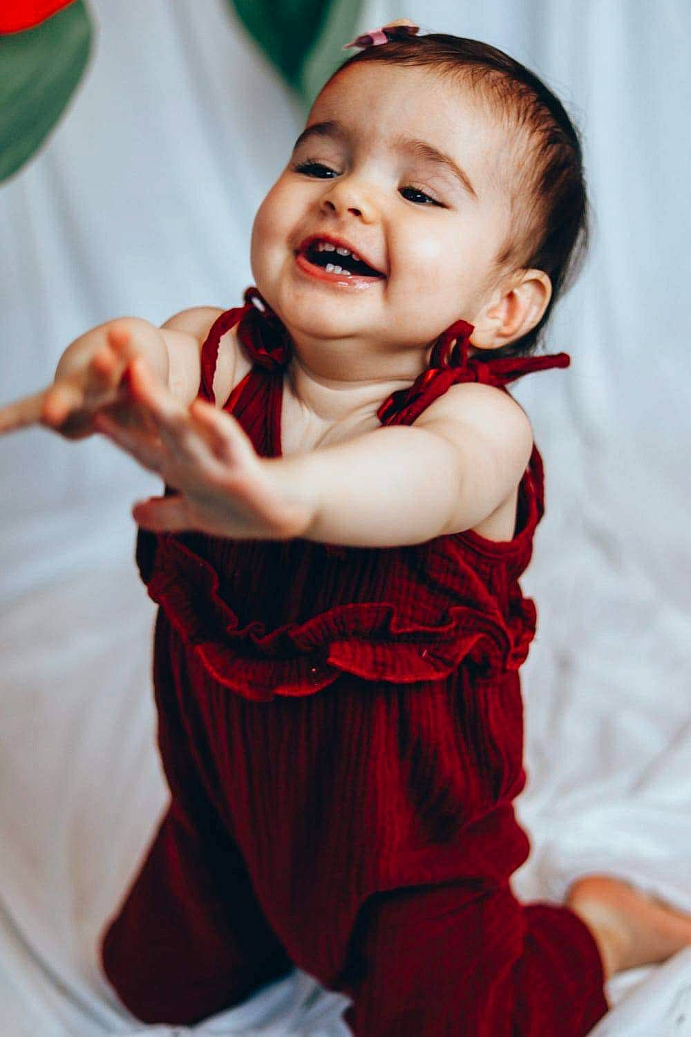 Sophia participe au concours pour gagner de l'argent avec cette photo : baby, baby_toddler_clothing, cheek, dress, eye, face, finger, flash_photography, gesture, green, hair, happy, head, iris, lip, person, red, skin, sleeve, smile