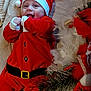 baby, santa_claus_costume, christmas, holiday, festive, smiling, blanket, red_clothing, hat, face, infant, joyful, decorations, tree, greenery, white_feathers, cute, celebration, happy, indoors