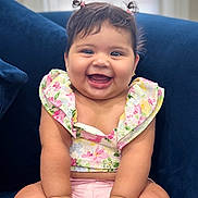 Mila joined the competition — help win amazing prizes! accessory, baby, blue_couch, bracelet, child, chubby_cheeks, clothing, couch, cute, floral_top, happy, indoor, infant, joyful, person, pigtails, pink_shorts, portrait, sitting, smiling